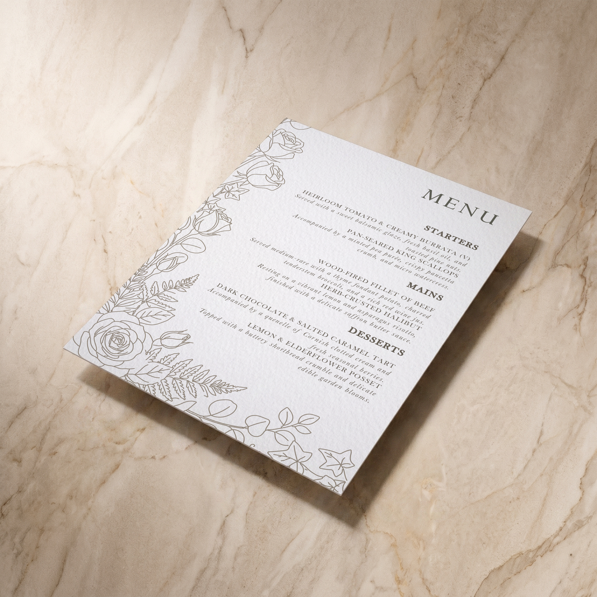 A rectangular printed menu card with elegant black text and floral line art along the left side, photographed on a light beige marble surface.