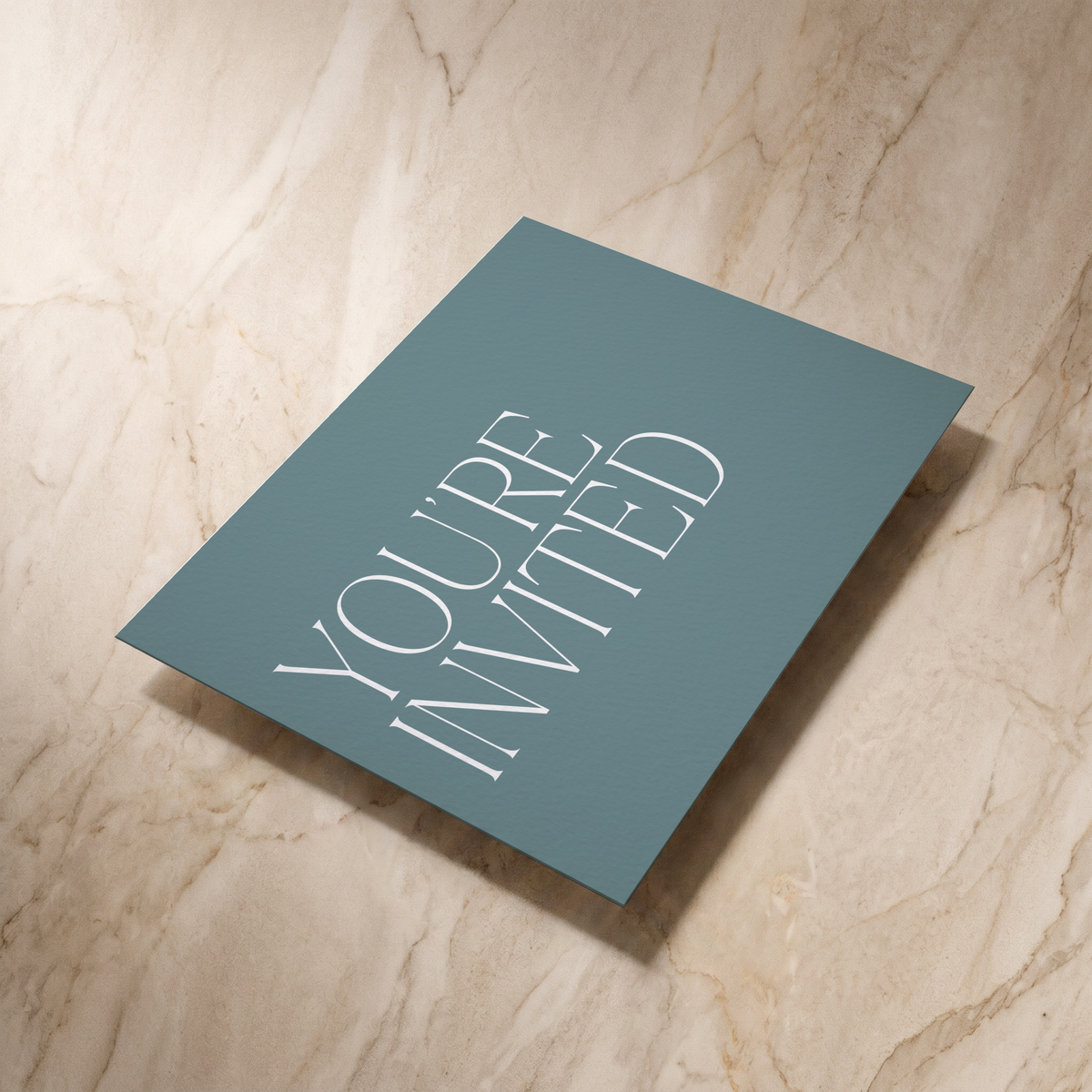 Typeface wedding invitation in powder blue, reverse shown at an angle, designed and printed in Suffolk