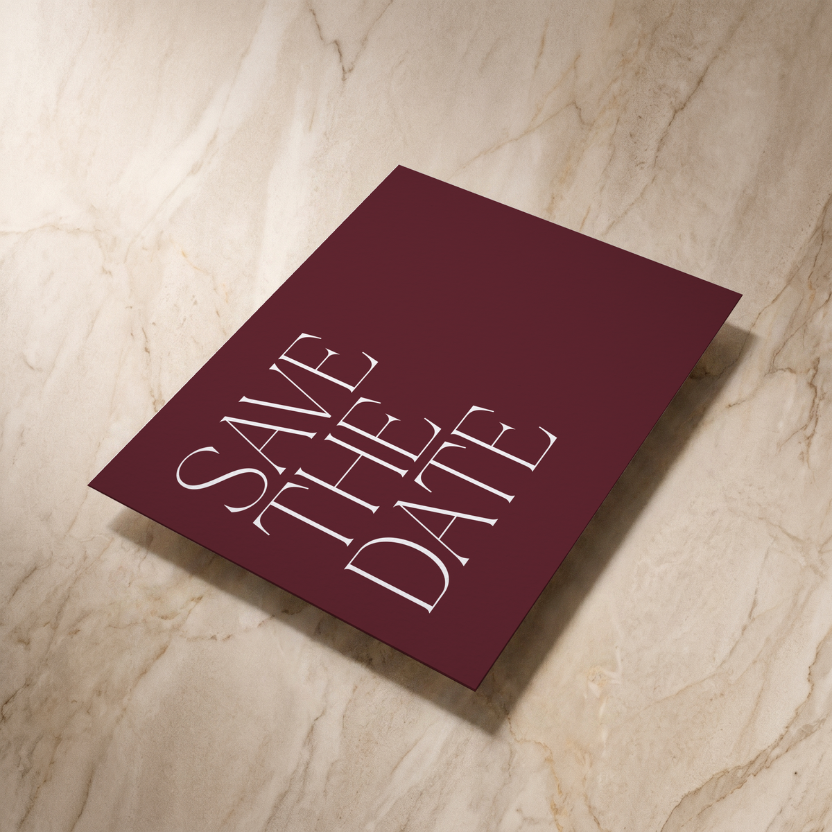 Typeface save the date card in maroon, reverse shown at an angle, designed and printed in Suffolk