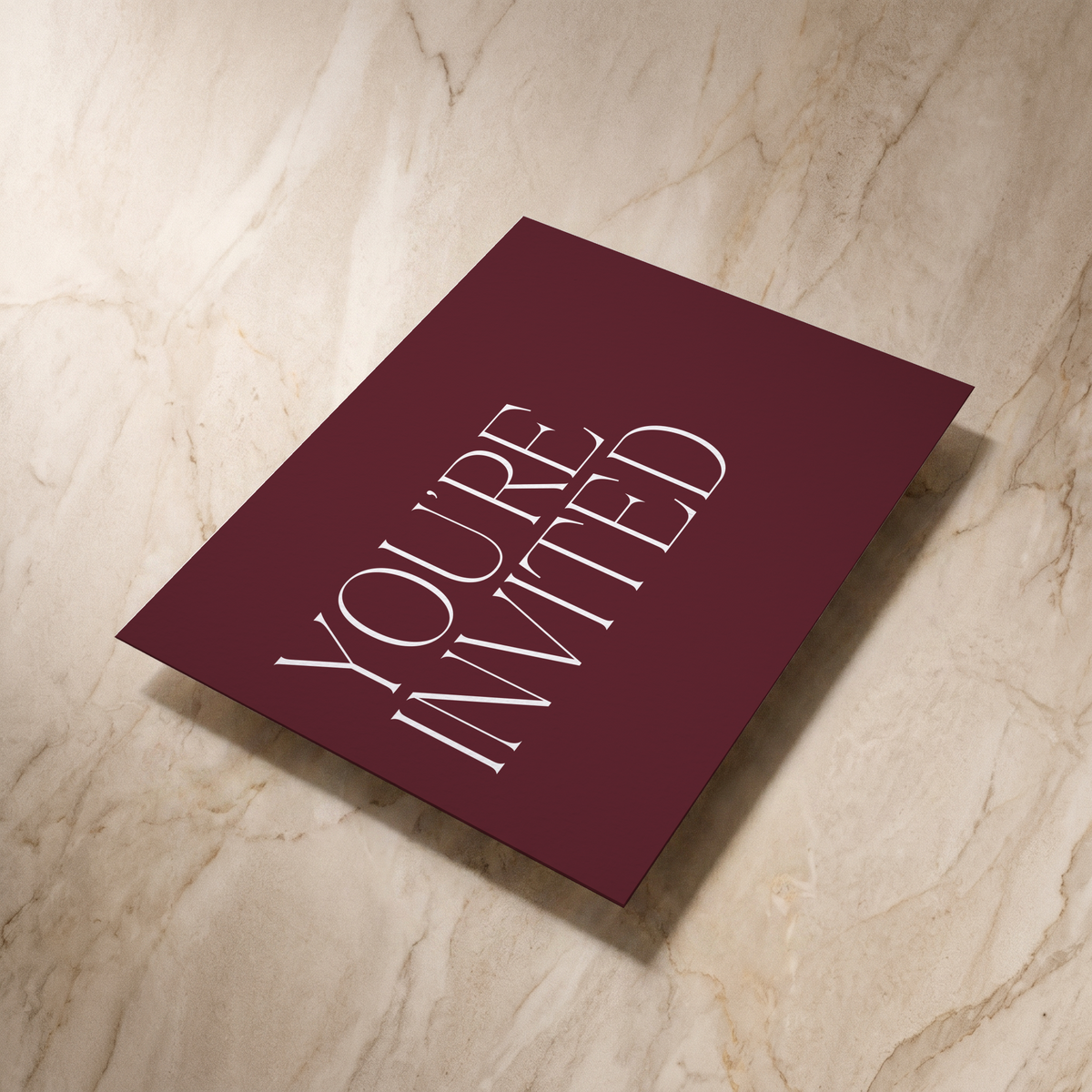 Typeface wedding invitation in maroon, reverse shown at an angle, designed and printed in Suffolk