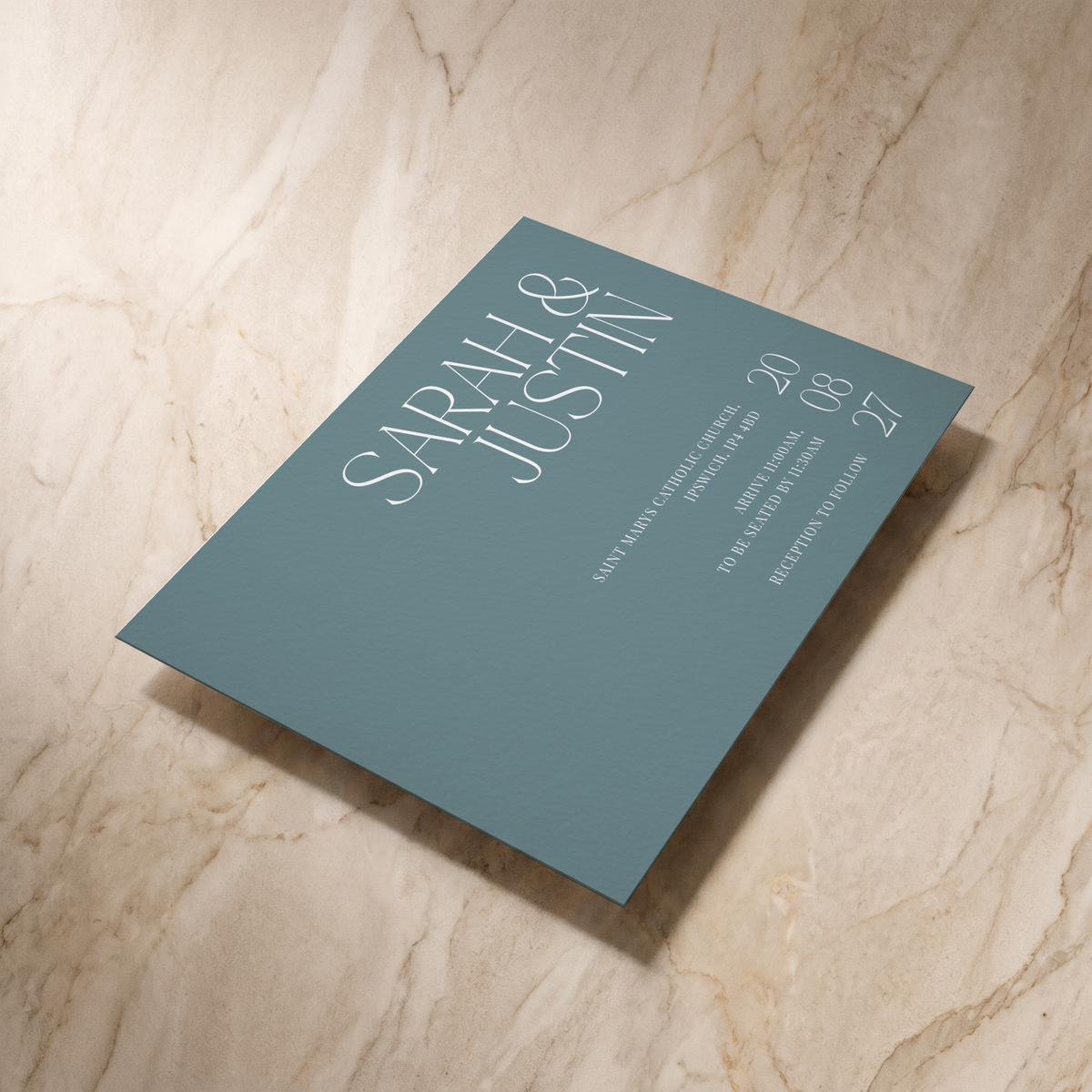 Typeface wedding invitation in powder blue, shown at an angle, designed and printed in Suffolk