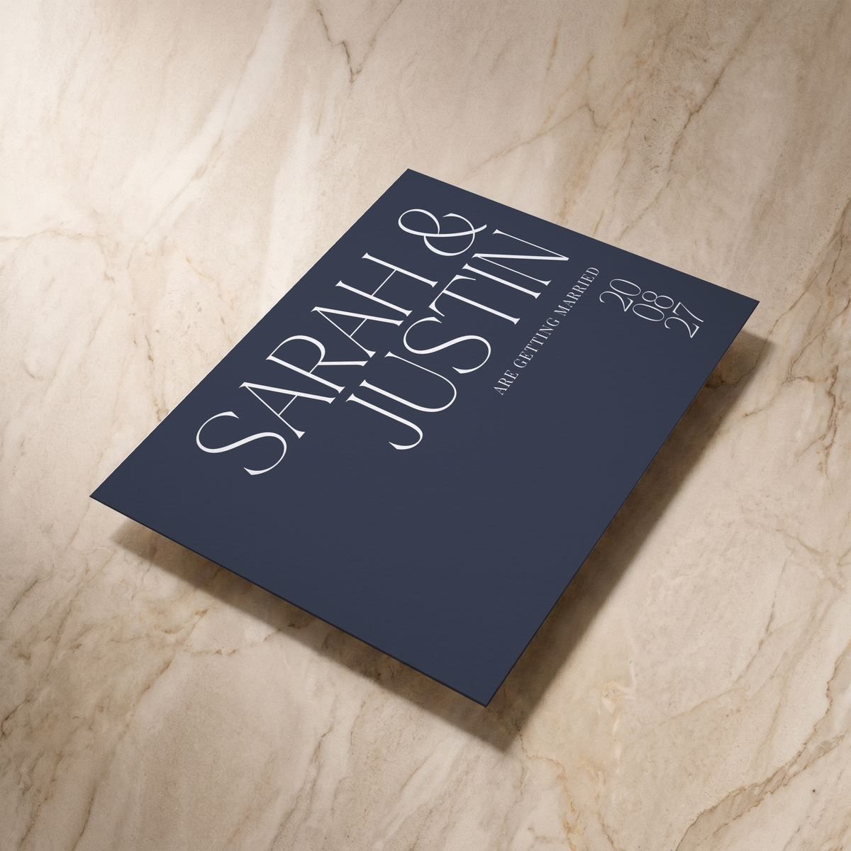 Typeface save the date card in navy, shown at an angle, designed and printed in Suffolk