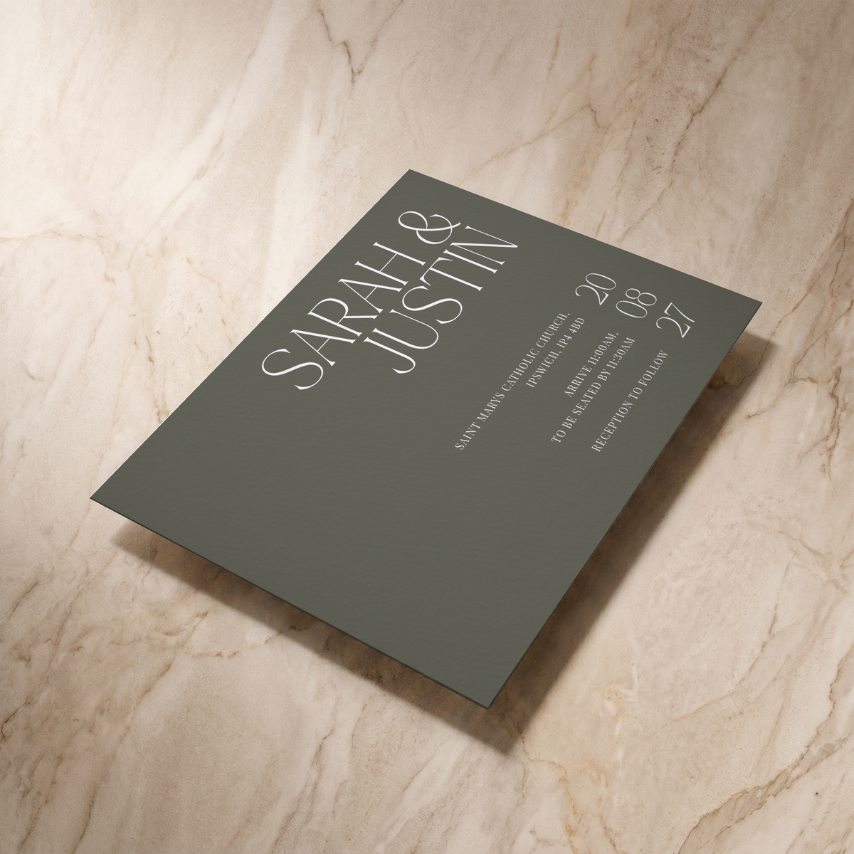 Typeface wedding invitation in forest green, shown at an angle, designed and printed in Suffolk