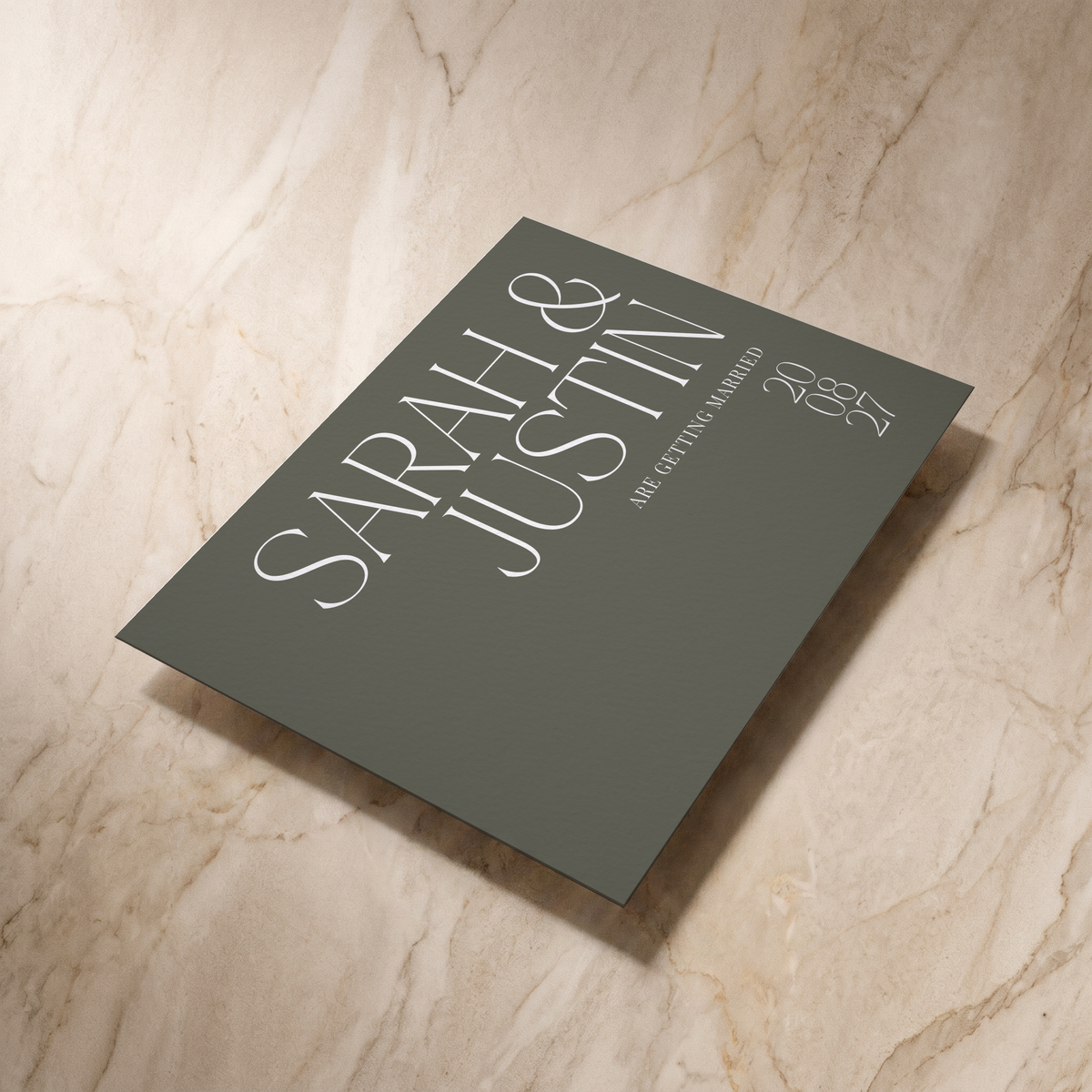 Typeface save the date card in forest green, shown at an angle, designed and printed in Suffolk
