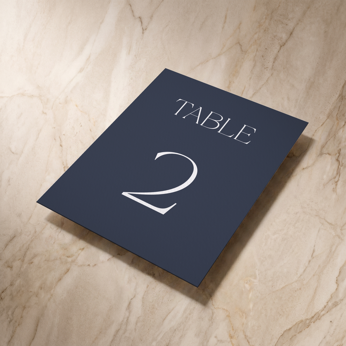 Typeface table number card in navy, shown at an angle, designed and printed in Suffolk