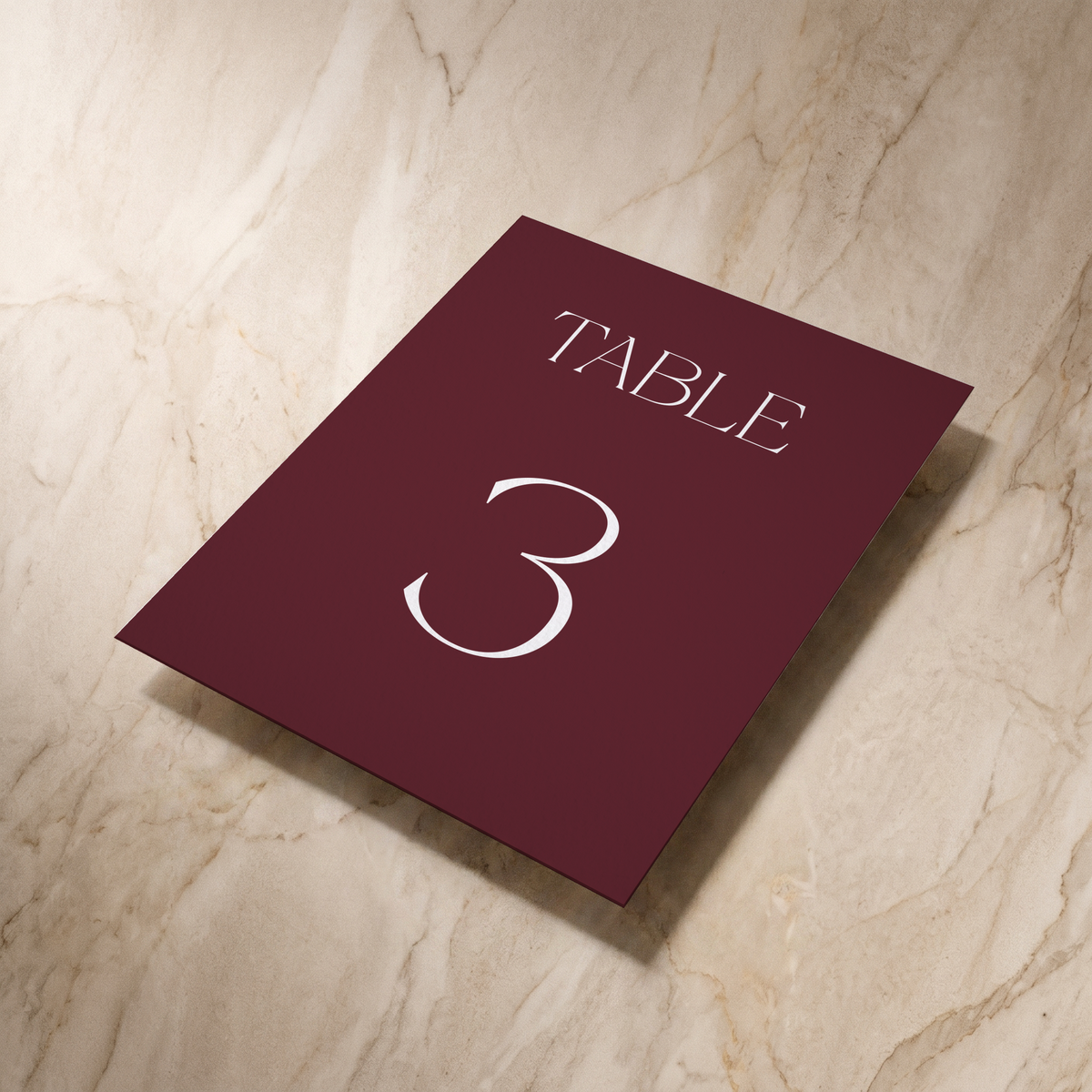 Typeface table number card in maroon, shown at an angle, designed and printed in Suffolk