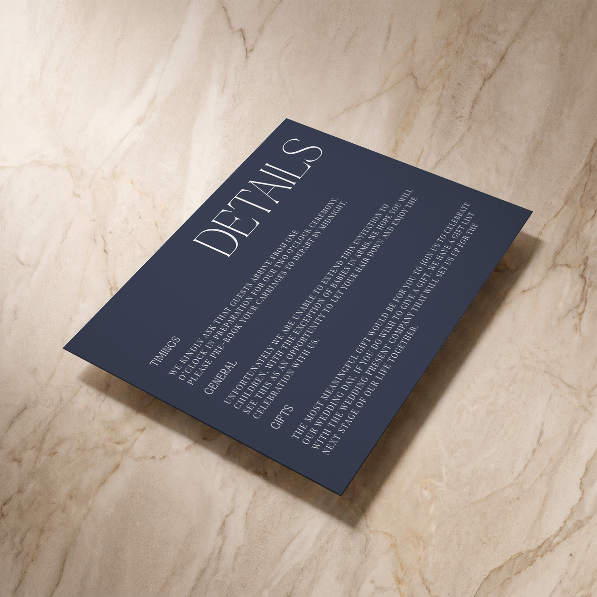 Typeface wedding details card in navy, shown at an angle, designed and printed in Suffolk